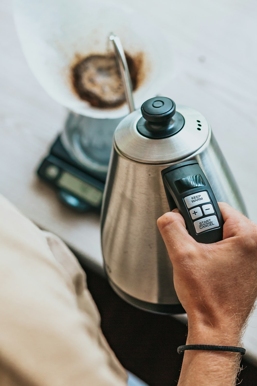 person holding silver stainless steel electric kettle