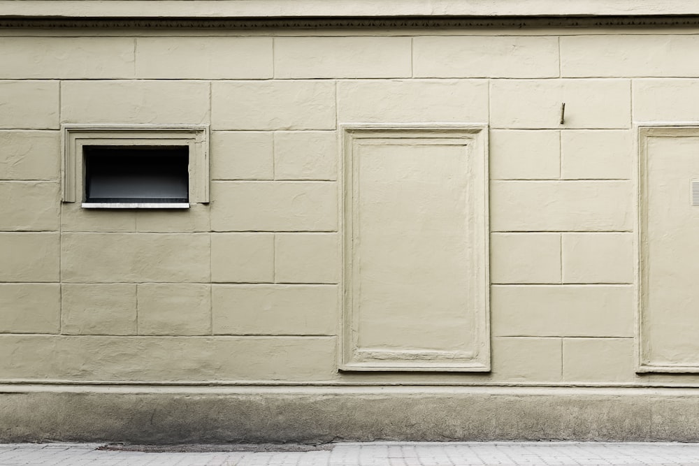 closed wooden window beside concrete curb