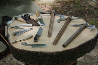 A collection of knives arranged neatly on a rustic wooden table.
