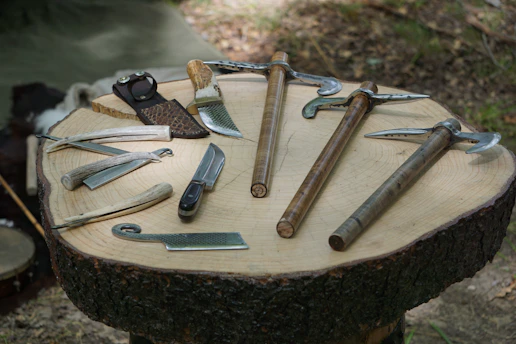 A close-up of farming tools neatly arranged on a wooden table under natural light.