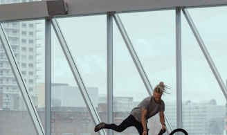 man riding bicycle doing stunts inside glass building during daytime