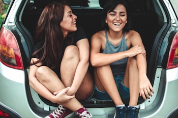 two women sitting at the back of the car