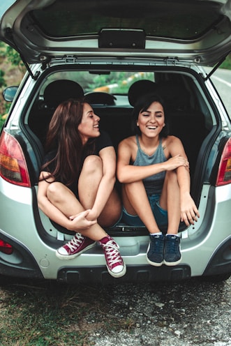 two women sitting at the back of the car