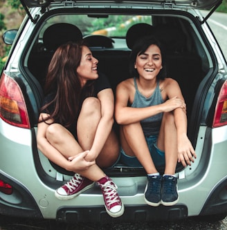 two women sitting at the back of the car