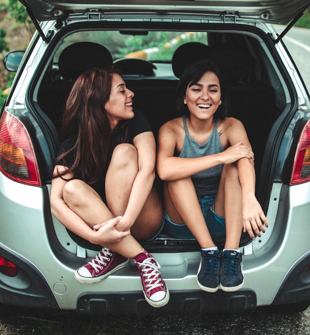 two women sitting at the back of the car