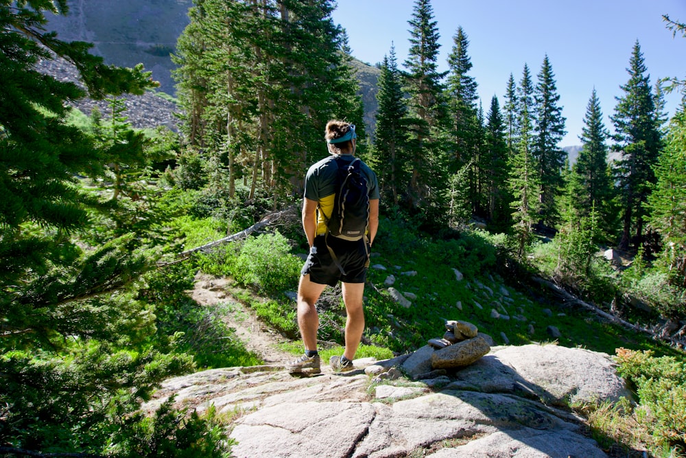 man standing in front of pine trees