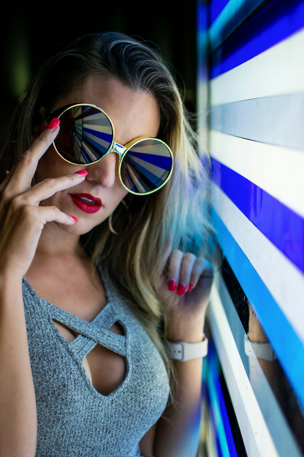 woman in gray top holding eyglasses