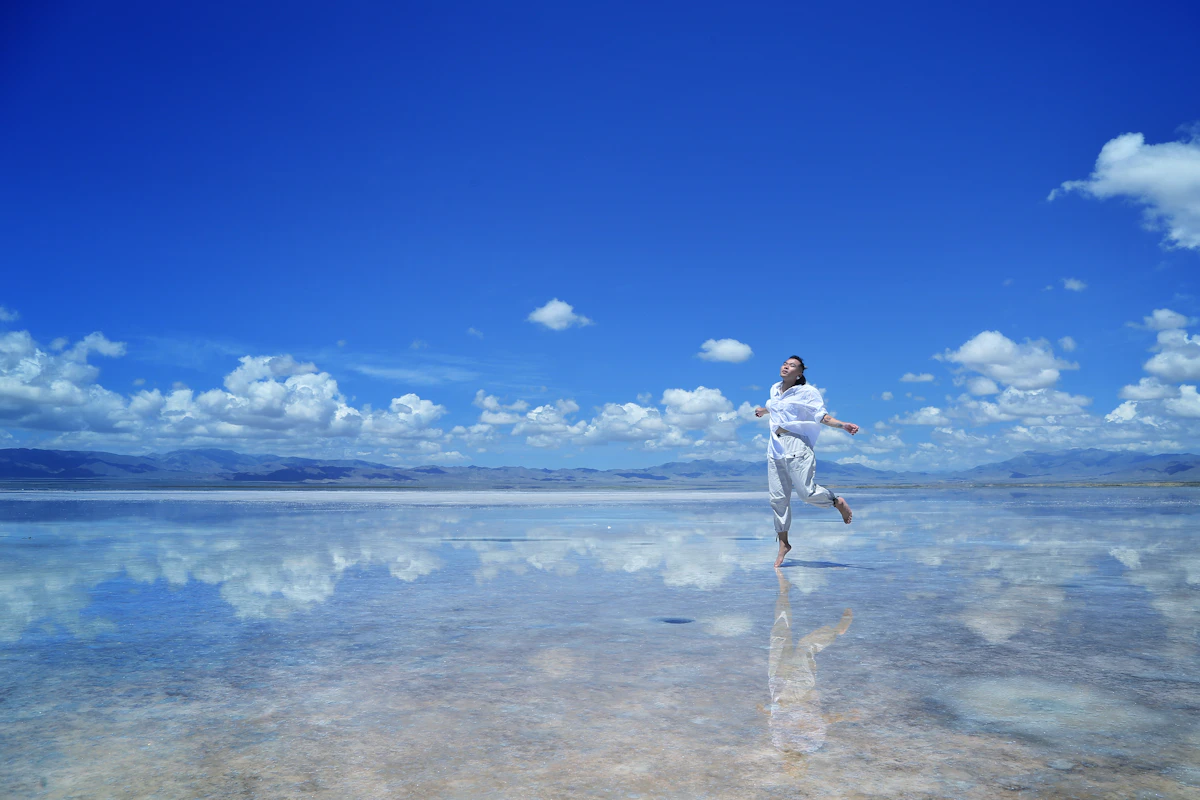 Woman walking on water at dusk in white shirt