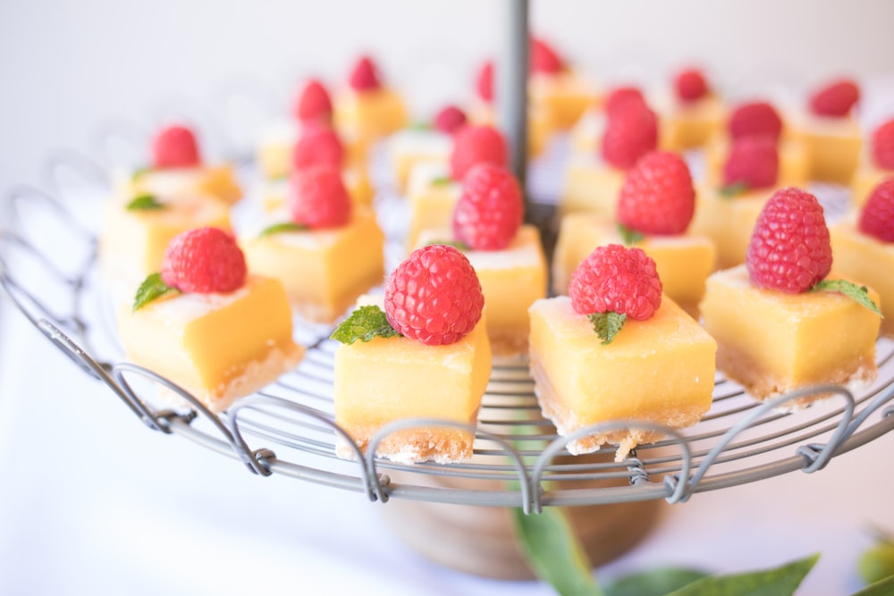 Tarta de queso de fresa cuadrada sobre soporte redondo de metal gris