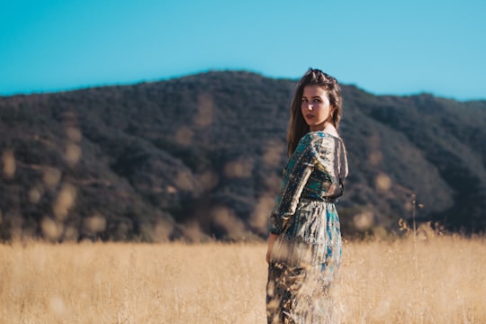 woman wearing brown and black jumpsuit in the middle of brown grass in California United States