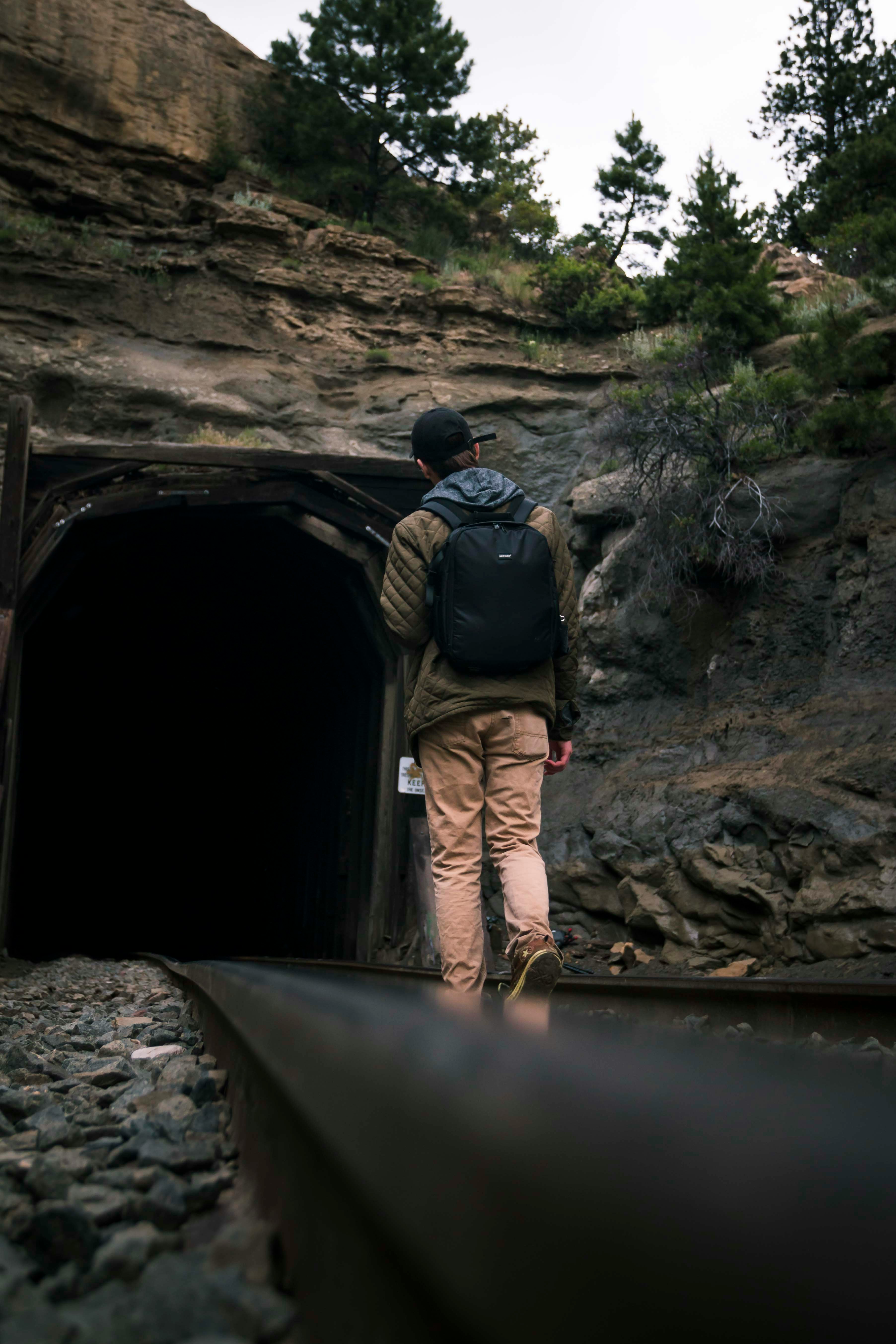 man walking towards tunnel