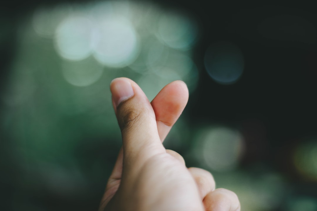 thumb and index finger in snapping motion with green background