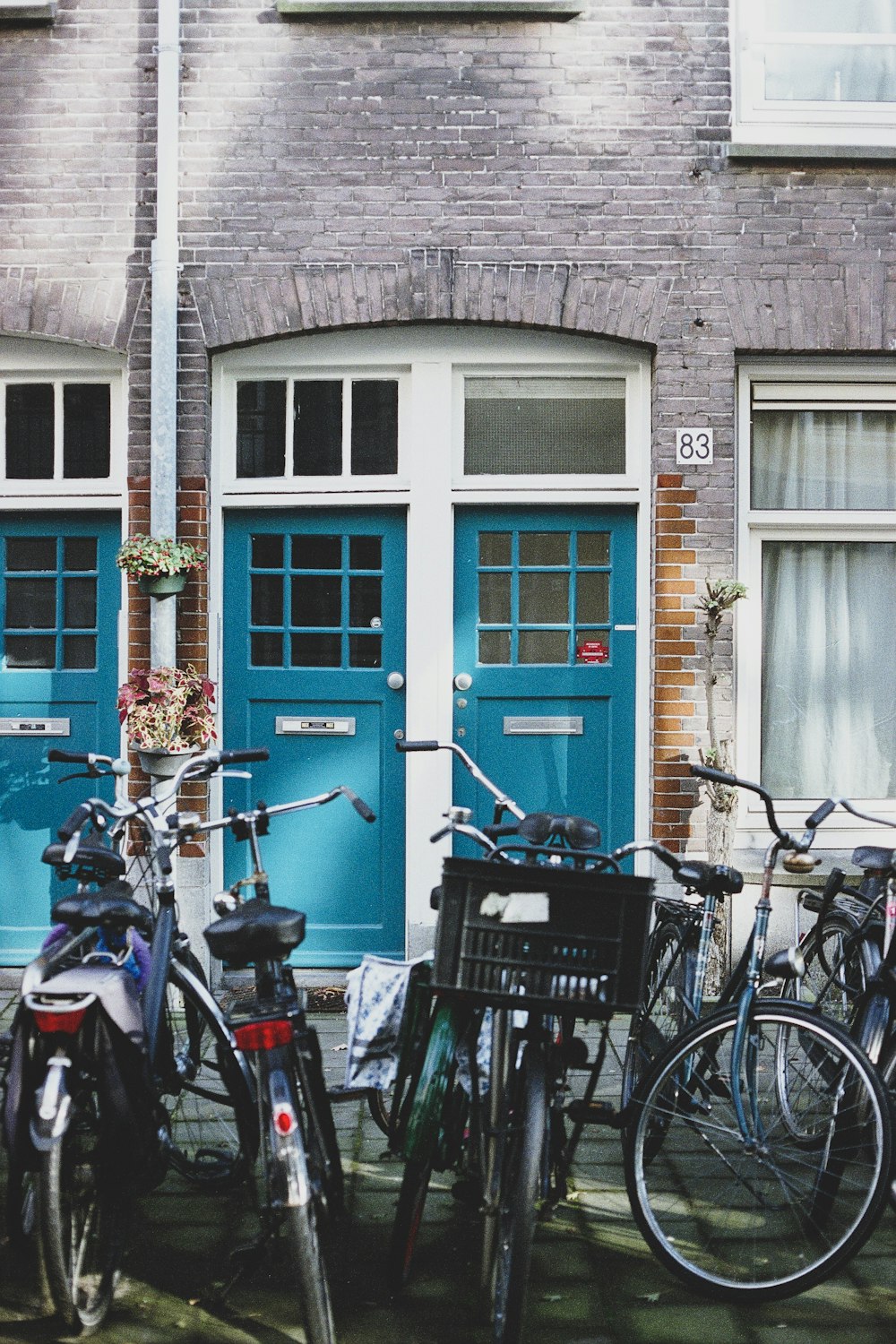 Bicicletas de varios colores frente a un edificio de hormigón marrón durante el día