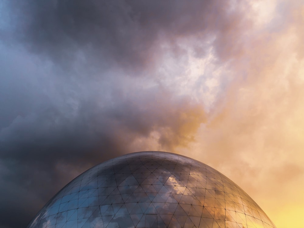 cúpula de vidro cinza com nuvens escuras acima dela