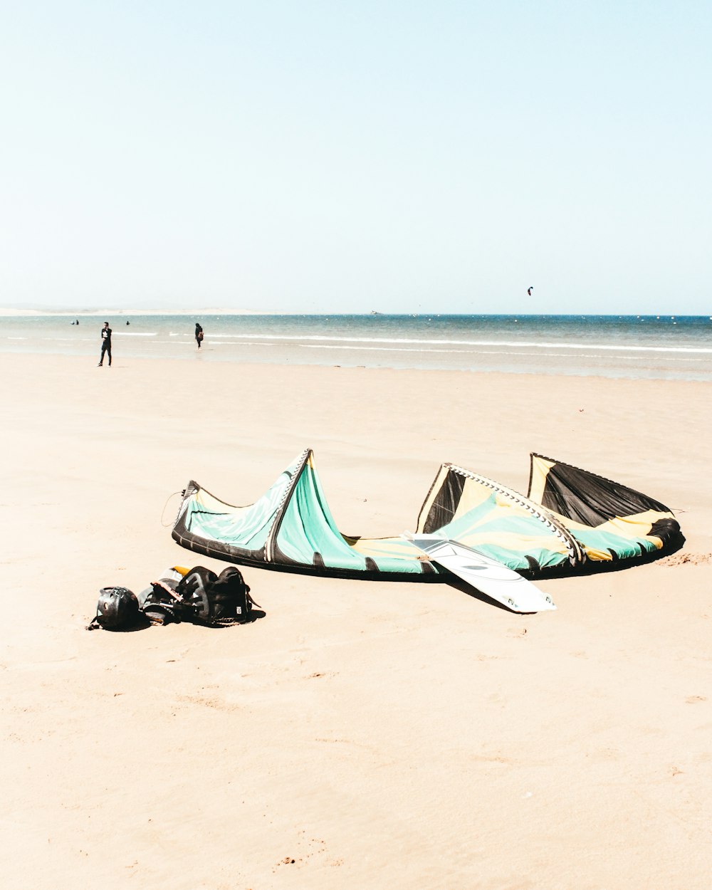 Planche de surf blanche sur le sable près d’un plan d’eau