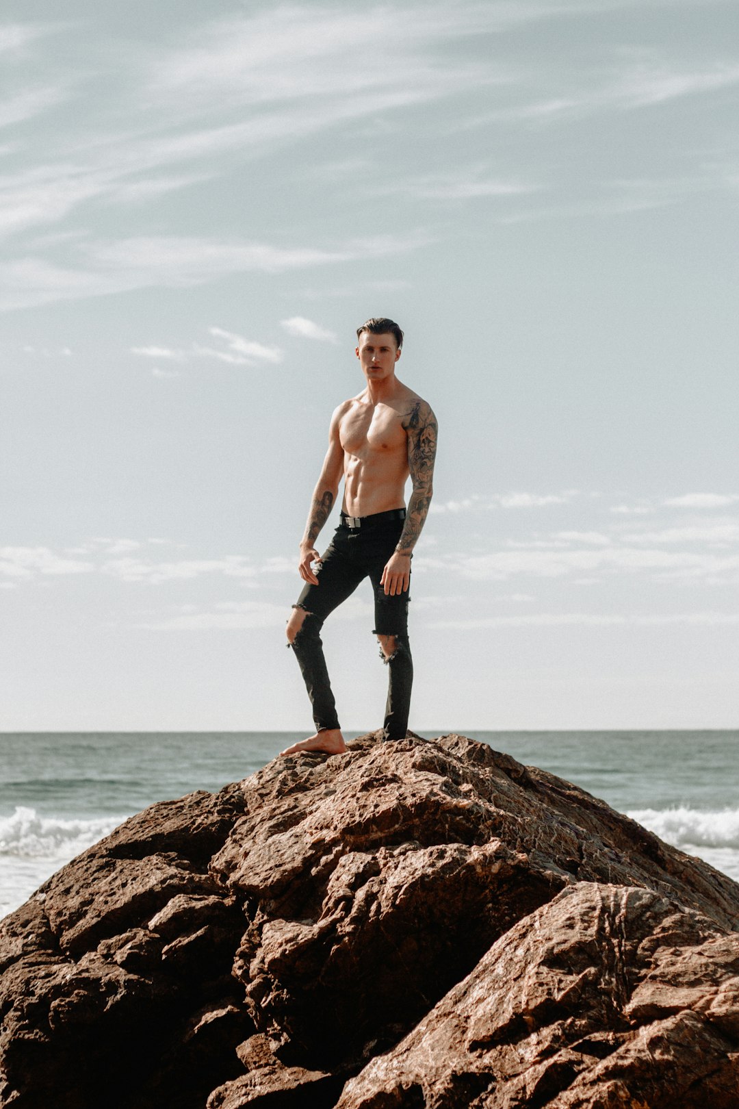 man in black pants standing on hill