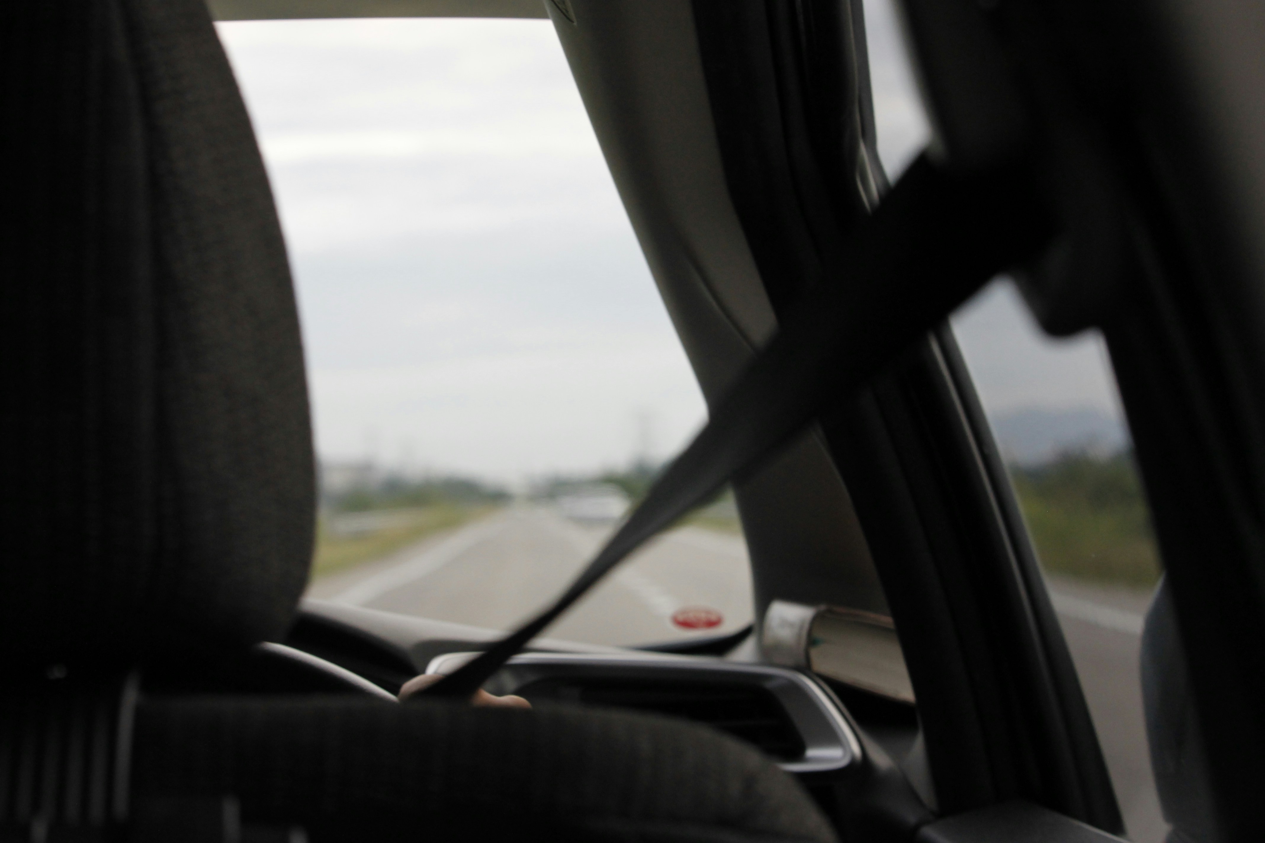 Someone driving a car with his seat-belt on