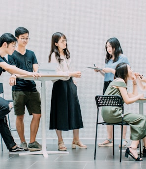 two men and four women meeting in office