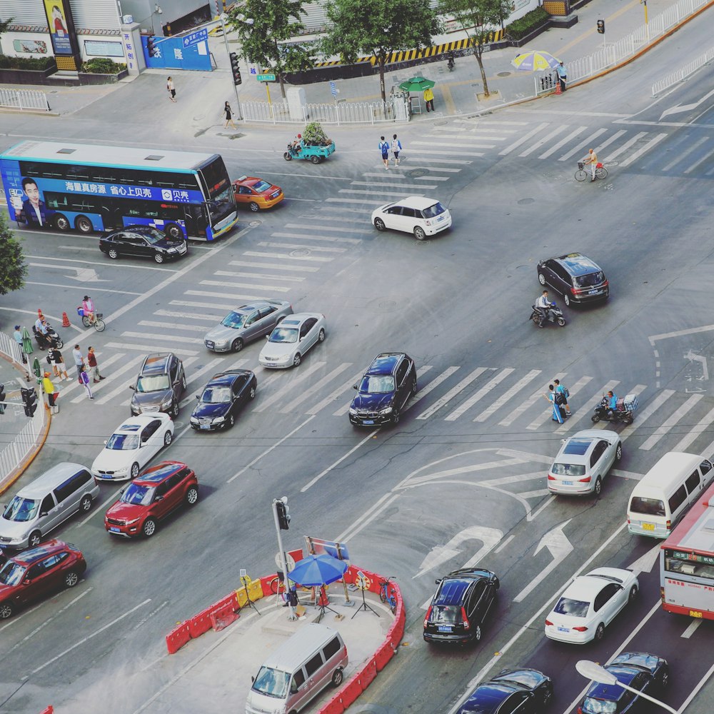 Carretera de intersección con vehículos que circulan y personas que cruzan por el carril peatonal