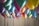 A collection of brightly colored balloons is grouped together, each with a long ribbon attached. The balloons feature a variety of colors including green, pink, blue, yellow, and purple, creating a festive and celebratory atmosphere.