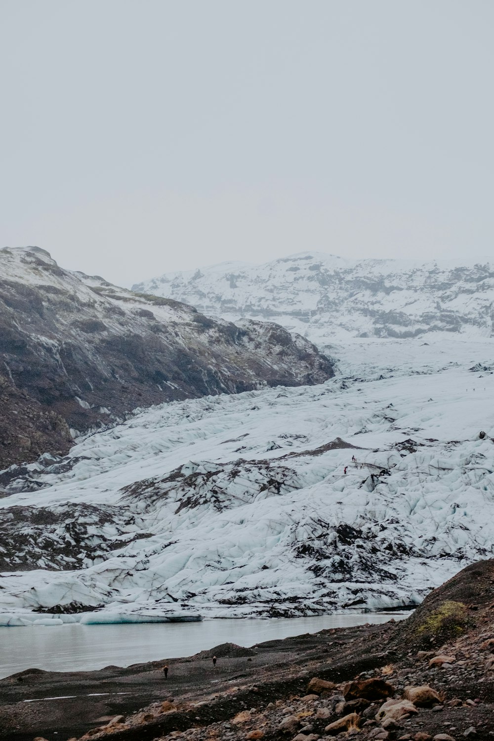 colinas cubiertas de nieve bajo el cielo nublado durante el día