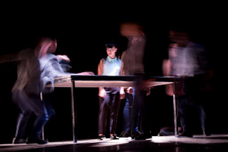 A dynamic shot of people gathered around a table, sharing moments as time passes.