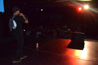 Close-up of a comedian on stage with a microphone, spotlight highlighting the expression.