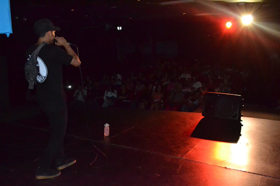 Kevin Mattson performing live on stage with a warm spotlight capturing his animated storytelling.