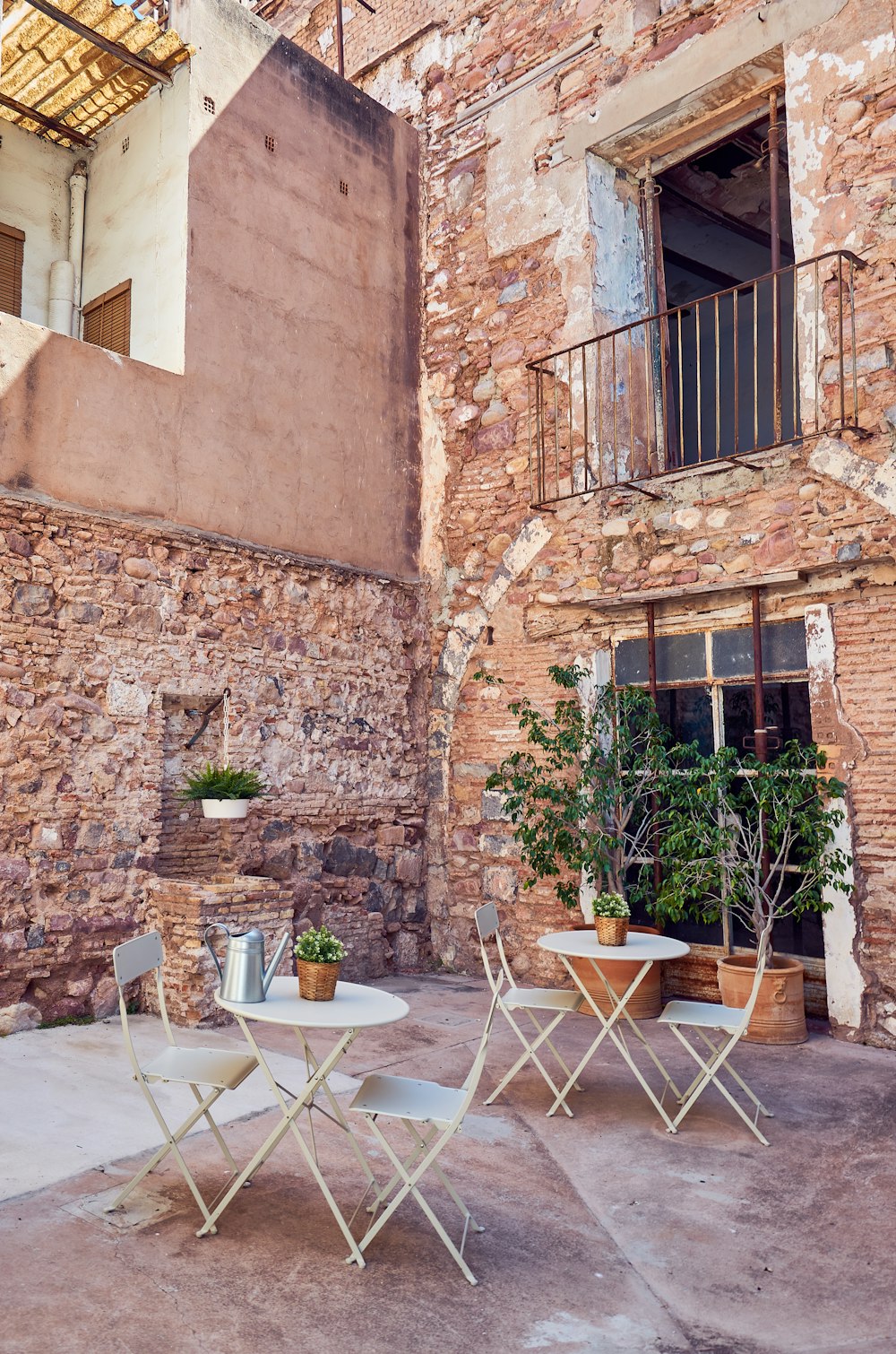 two sets of table and 2-piece chair set outside building