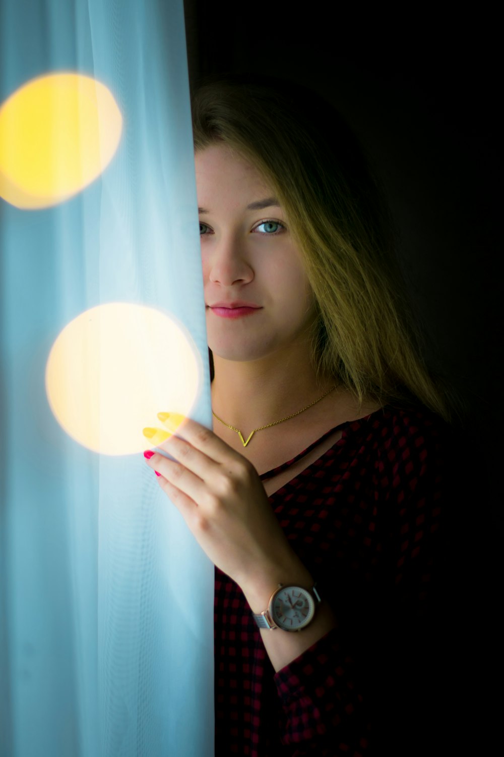 photography of woman behind curtain