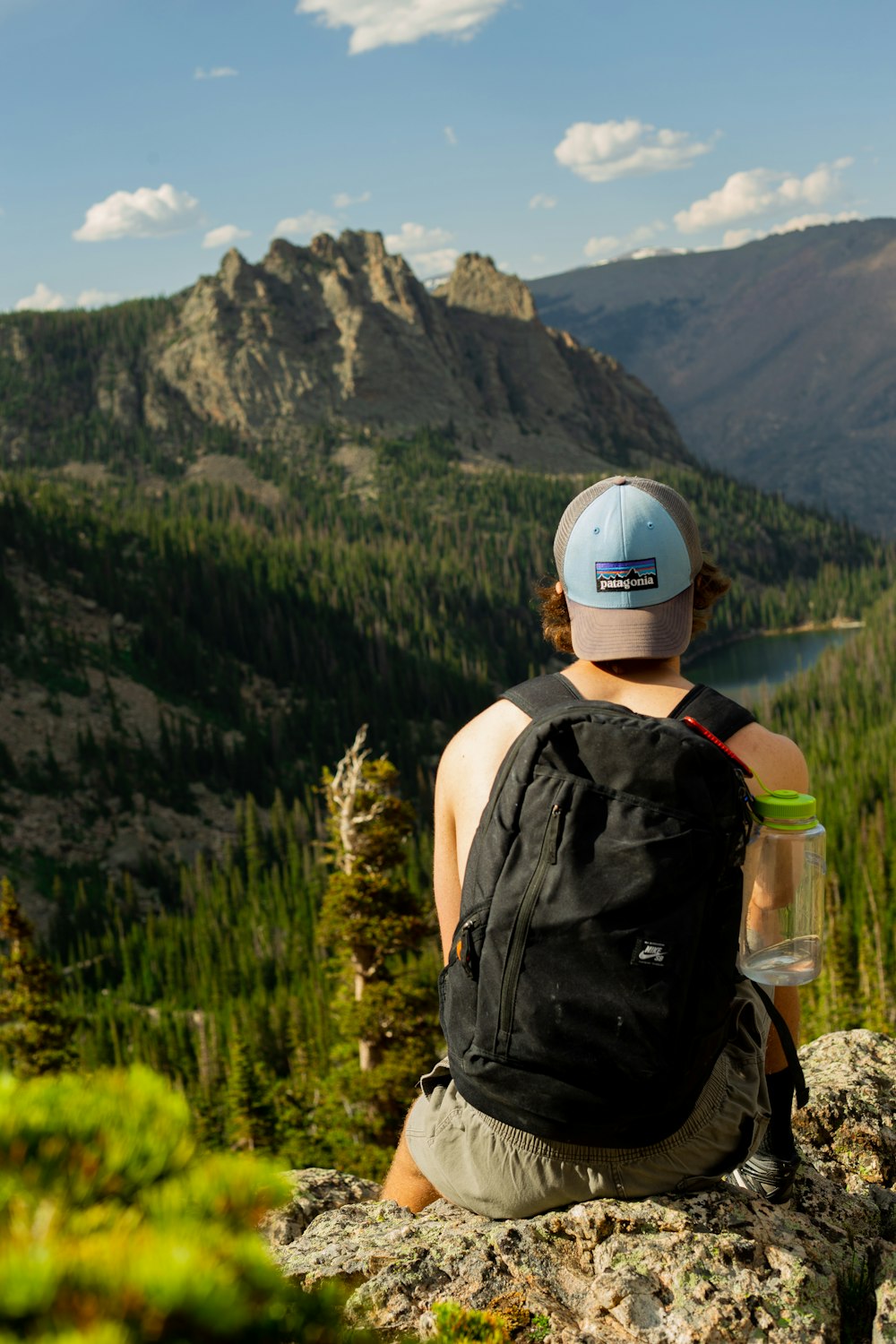 man sitting on stone looking at mountain