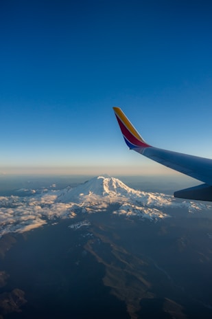 white and red airliner tail under blue sky