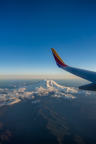 white and red airliner tail under blue sky