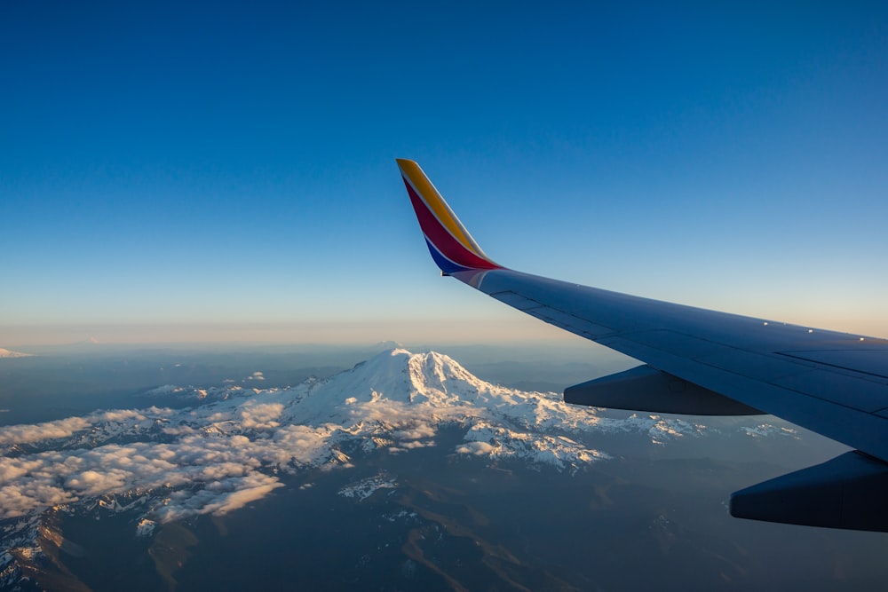 commercial airplane wing view fly over alpine mountain