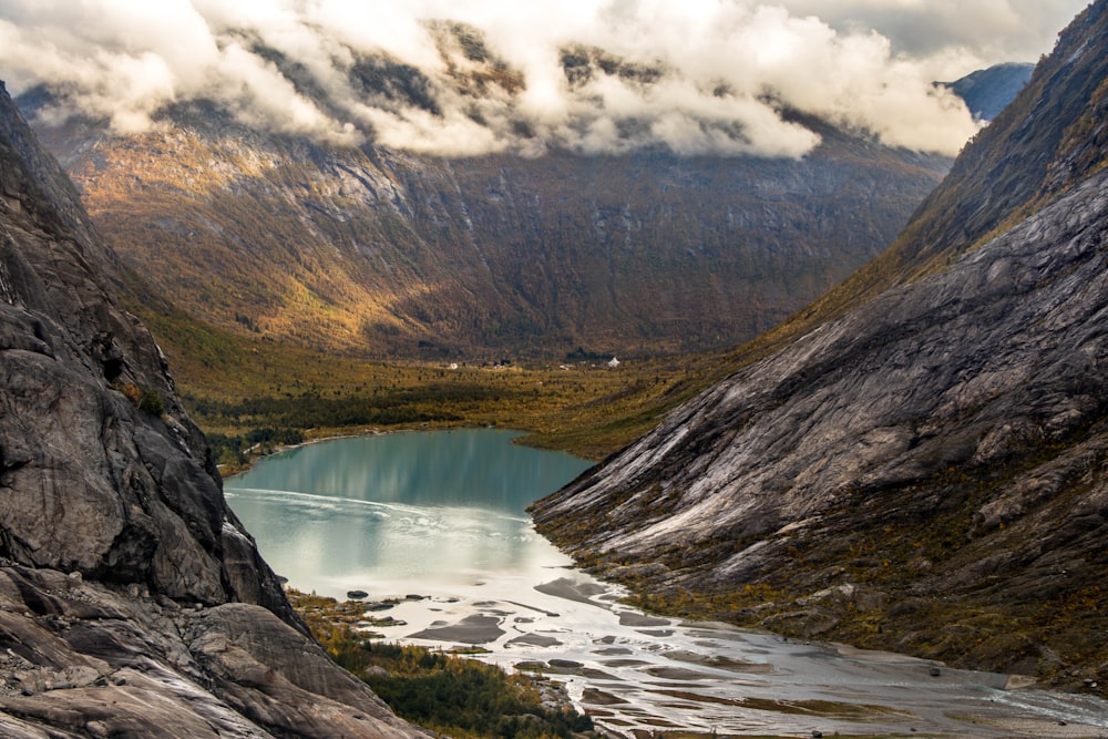 landscape photography of body of water between mountain