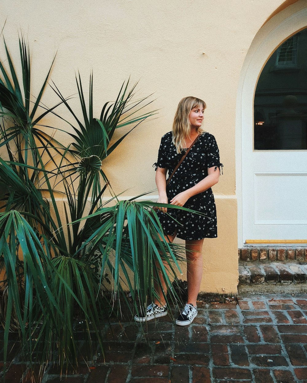 woman wearing mini dress beside beige wall