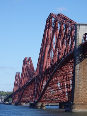 A sturdy steel bridge spanning a river, showcasing intricate metalwork.