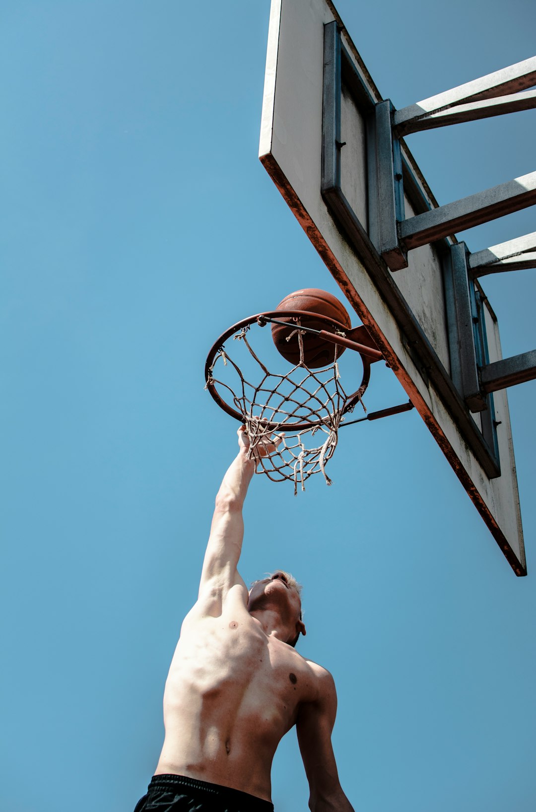 person about to dunk under blue sky