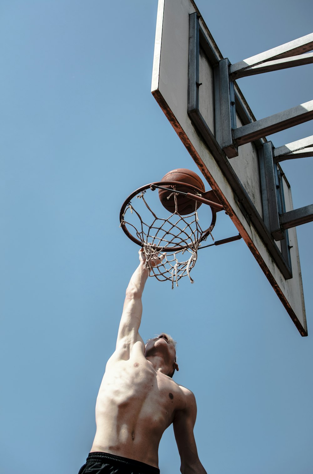 person about to dunk under blue sky