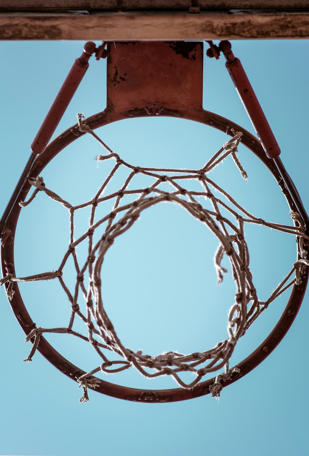 brown metal basketball rim under blue sky