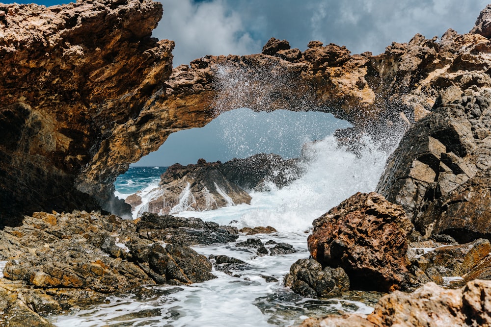 brown rock formation on body of water during daytime