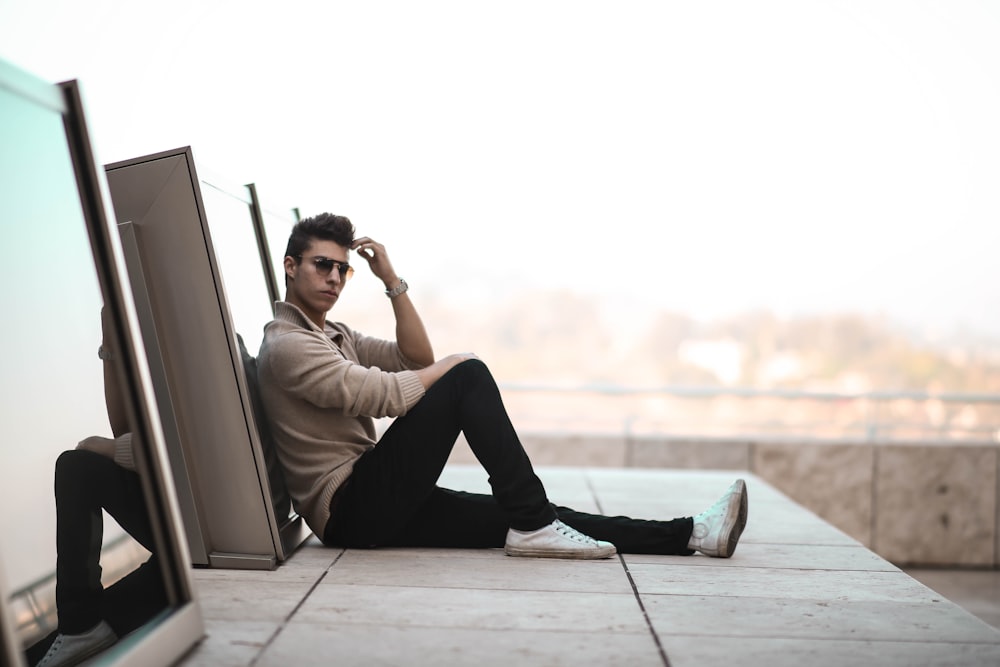 man sitting on gray concrete surface