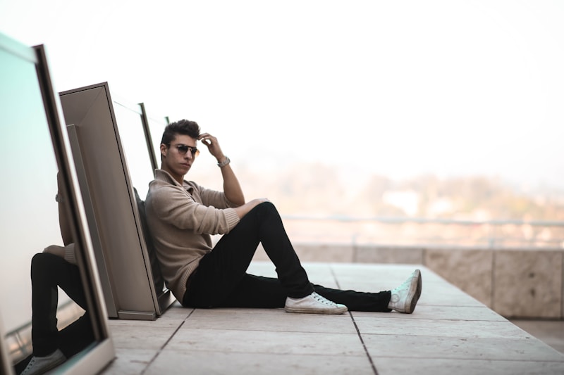 man sitting on gray concrete surface