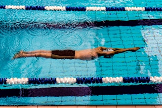 Athlete gliding through a clear pool during a swim training session.