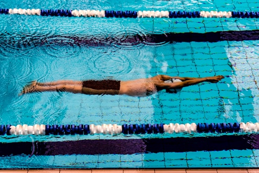 Athlete gliding through a clear pool during a swim training session.
