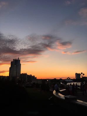 Outdoor team gathering with city skyline in the background during sunset.