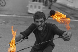 A fiery goblin mascot standing defiantly atop a pile of broken chains.
