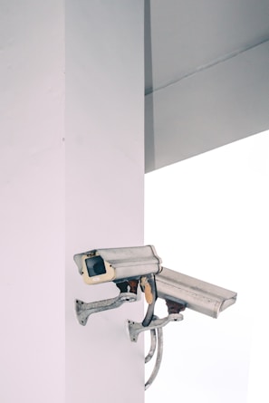 two bullet security camera attached on wall