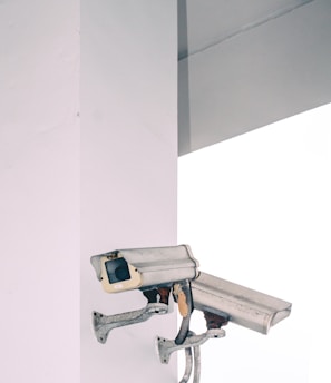 two bullet security camera attached on wall