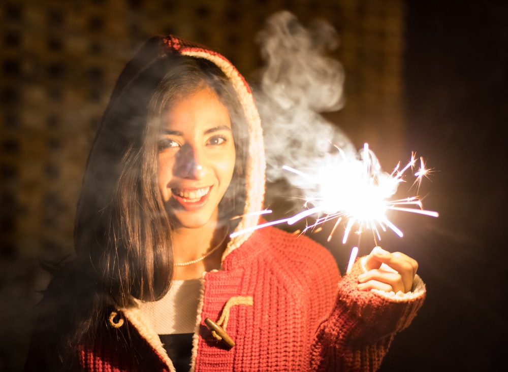 a woman holding a sparkler in her hand